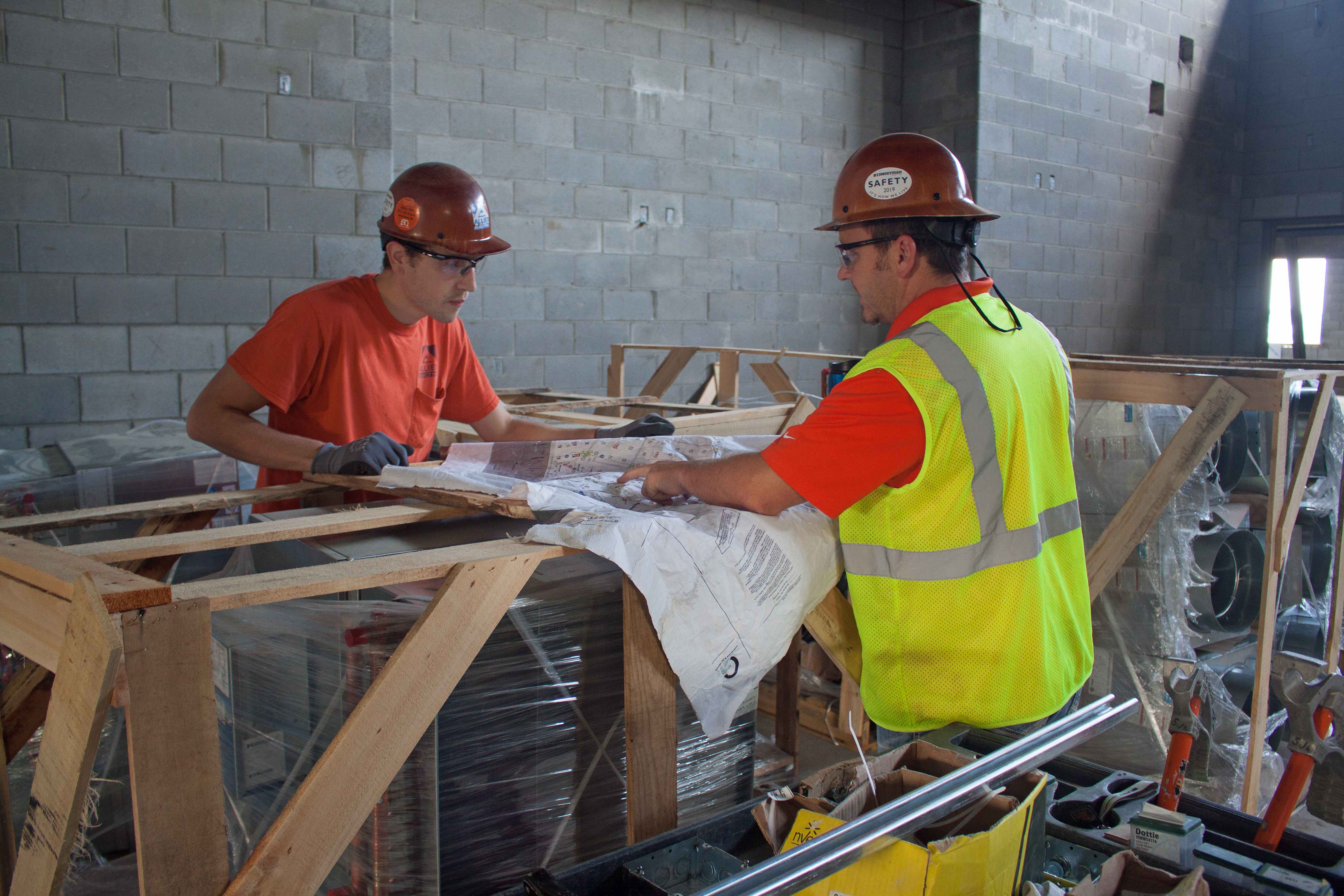 Allied Electric workers reviewing construction blueprints at job site