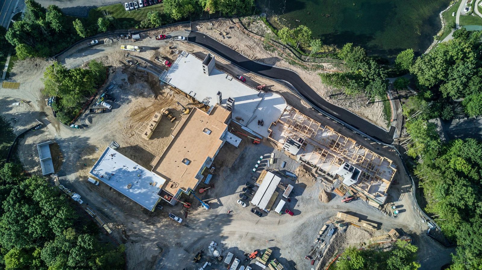 Aerial view of large commercial construction site showing building under construction with electrical infrastructure