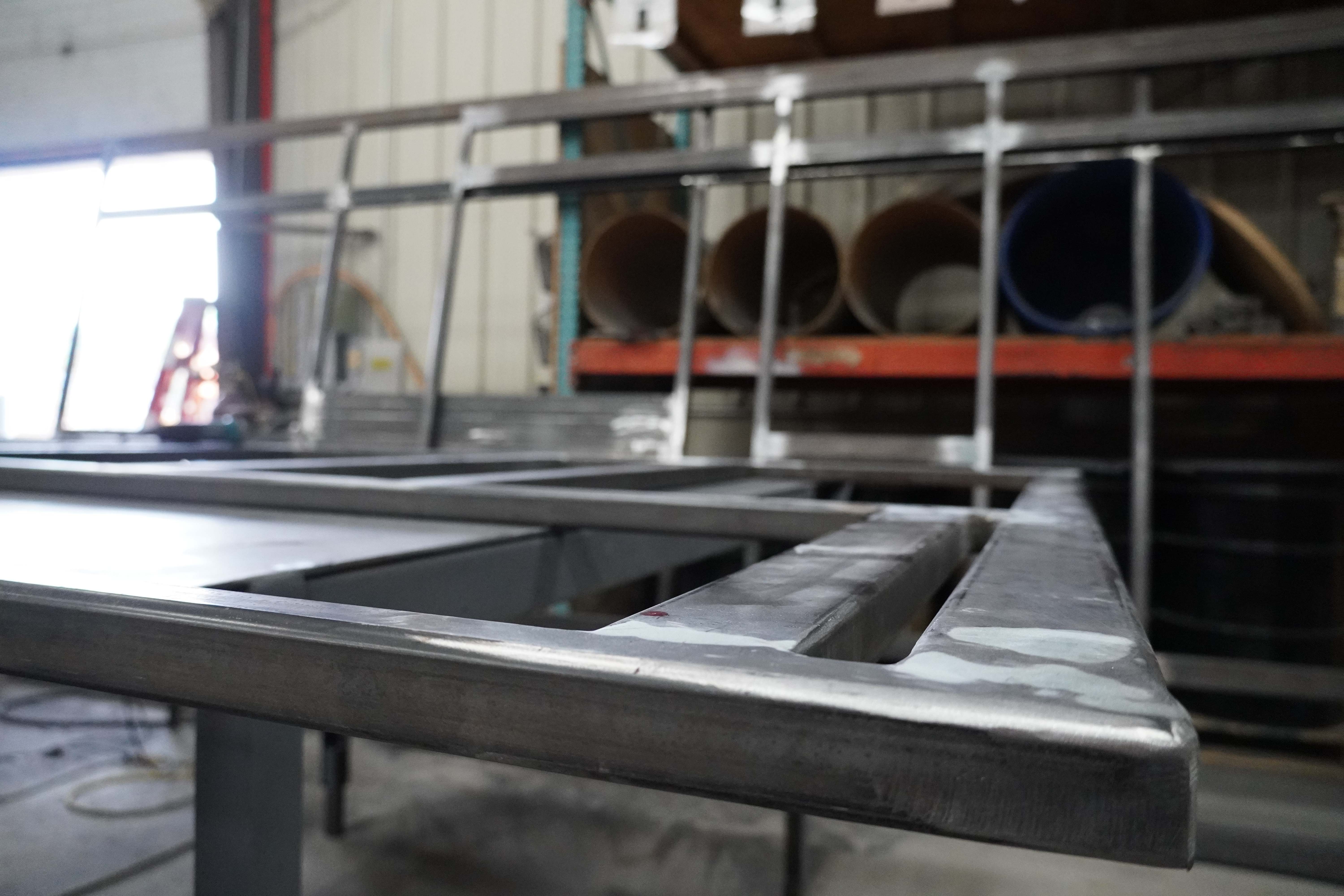 Metal fabrication work showing welded electrical enclosures and organized material storage in Allied Electric's Pre-Fabrication facility