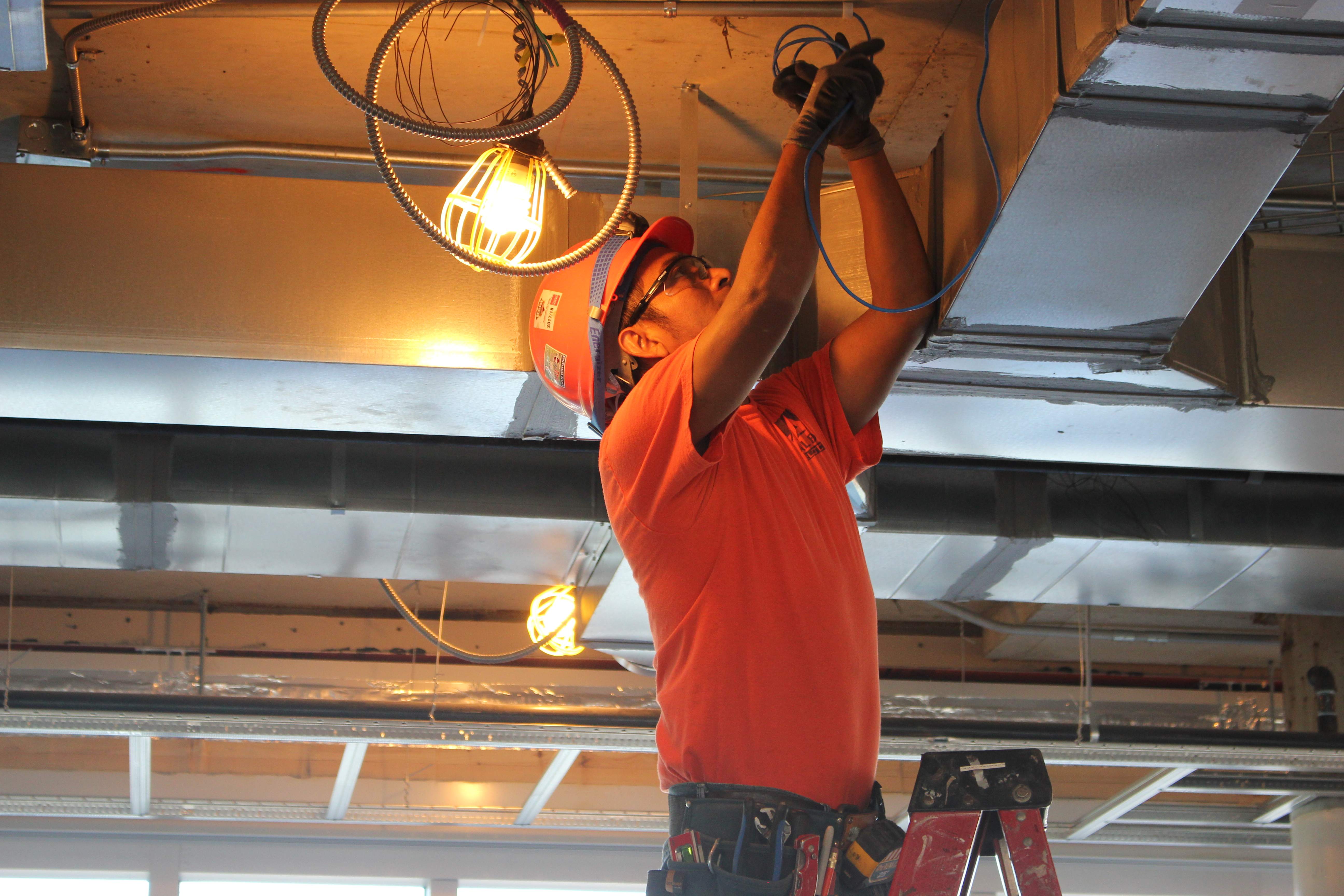 Allied Electric service technician performing electrical maintenance work with safety equipment